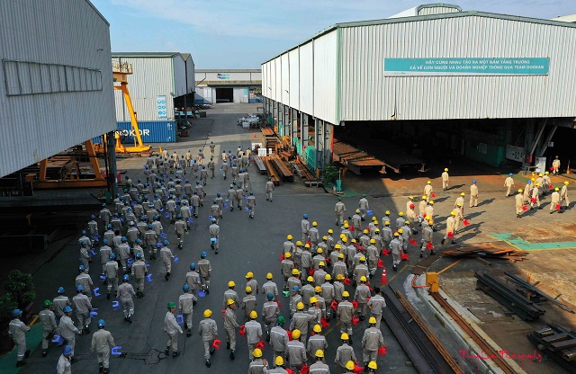 Workers gather in the factory area during industrial production activities.